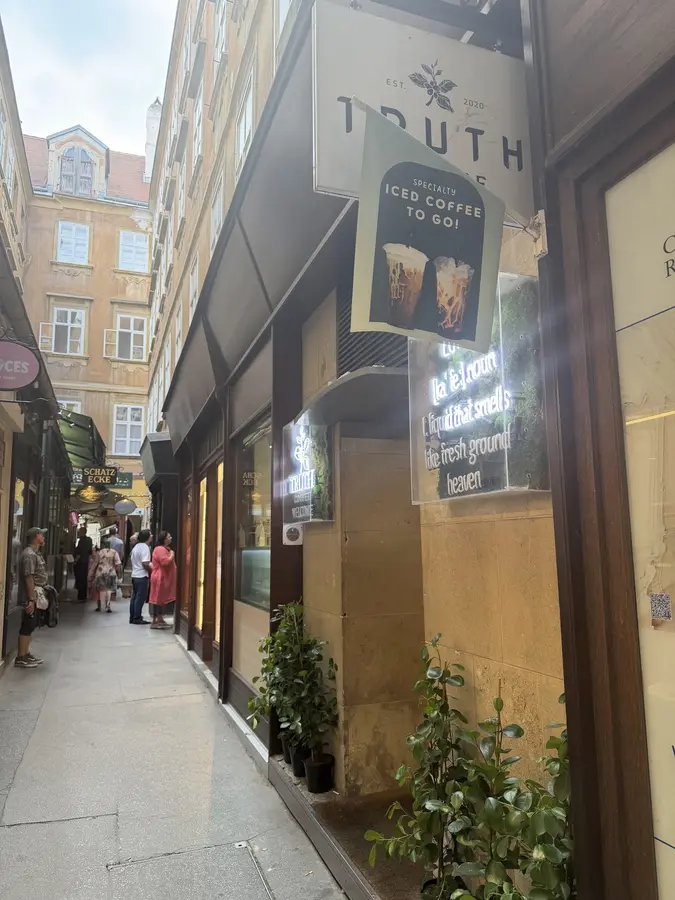 Die schmale Passage an der Wollzeile mit dem Truth-Schild, Neonschrift im Fenster und Grünpflanzen